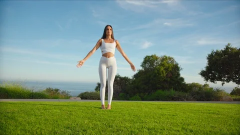 Yoga master doing yoga session at park with view on an ocean Stock Footage 129998396