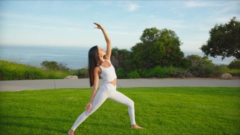 Yoga master doing yoga session at park with view on an ocean Stock Footage 129998520