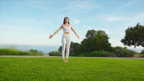Yoga master doing yoga session at park with view on an ocean Stock Footage 129998593