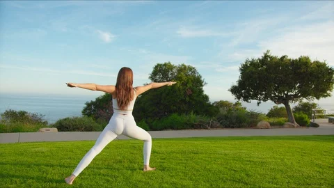 Yoga master doing yoga session at park with view on an ocean Stock Footage 129998621