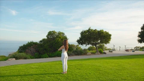 Yoga master doing yoga session at park with view on an ocean Stock Footage 129998638