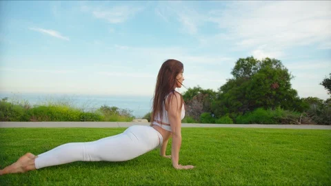 Yoga master doing yoga session at park with view on an ocean Stock Footage 129999017