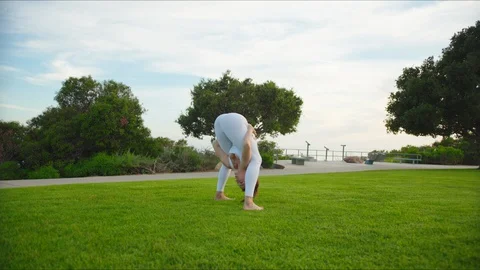 Yoga master doing yoga session at park with view on an ocean Stock Footage 129999099