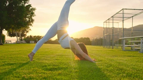 Yoga master doing yoga session at park, backlit sunlight Stock Footage 129999169