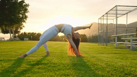 Yoga master doing yoga session at park, backlit sunlight 스톡 동영상 129999175