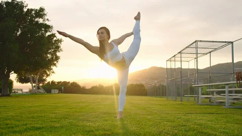 Yoga master doing yoga session at park, backlit sunlight Stock Footage 129999238