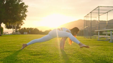 Yoga master doing yoga session at park, backlit sunlight Stock Footage 129999264