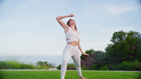 Yoga master doing yoga session at park with view on an ocean Stock Footage 130044452