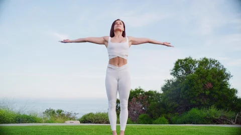 Yoga master doing yoga session at park with view on an ocean Video stock 130046096