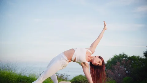 Yoga master doing yoga session at park with view on an ocean Video stock 130049083