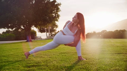 Yoga master doing yoga session at park, backlit sunlight Video stock 130049413