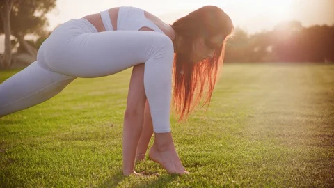 Yoga master doing yoga session at park, backlit sunlight Stock Footage 130049730