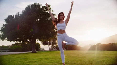Yoga master doing yoga session at park, backlit sunlight Stock Footage 130050292