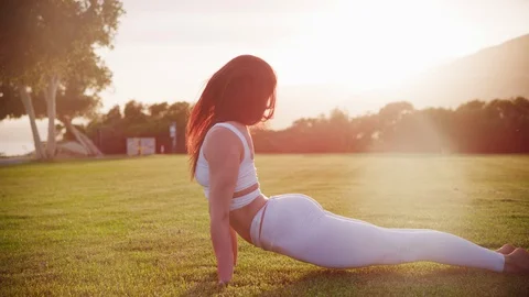 Yoga master doing yoga session at park, backlit sunlight Stock Footage 130050327