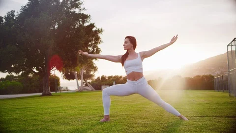 Yoga master doing yoga session at park, backlit sunlight Stock Footage 130050555