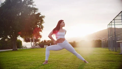 Yoga master doing yoga session at park, backlit sunlight Stock Footage 130050568