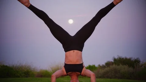 Yoga master doing yoga session at park, view with full moon Stock Footage 130052343