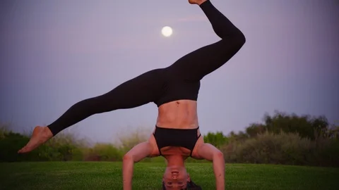 Yoga master doing yoga session at park, view with full moon Stock Footage 130052485