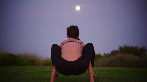 Yoga master doing yoga session at park, view with full moon Stock Footage 130052737