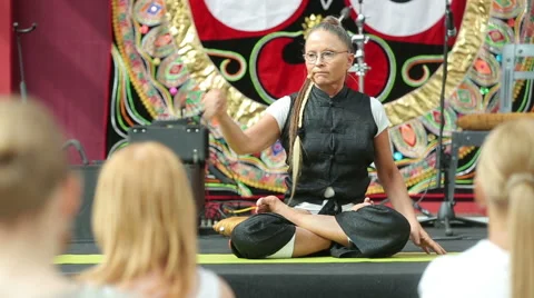 Yoga master shows students how to sit in the lotus position. Stock Footage 53225568