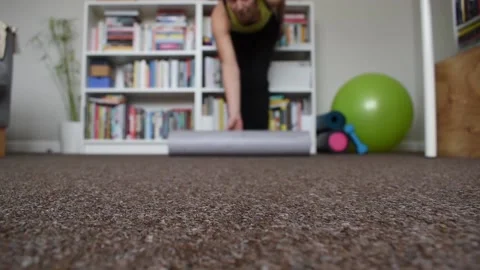 Yoga mat being rolled out for a home workout, floor point of view Stock Footage 165955362