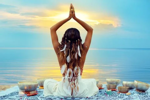 Yoga Meditation at Sunset Beach. Woman relaxing with Tibetan Singing Bowls Stock Photos