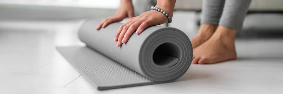 Yoga online class at home woman rolling mat on apartment floor for gym training Stock Photos