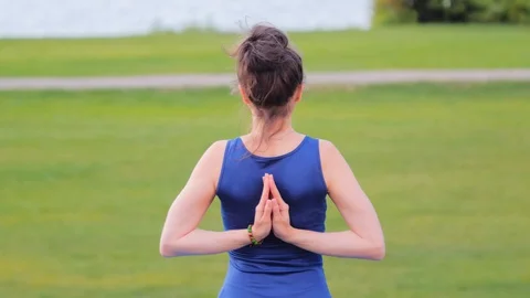 Yoga practicing in nature at the park, view from behind Stock Footage 129553310