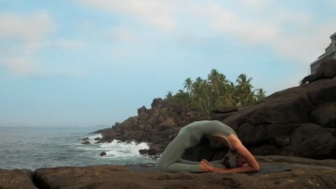 Yoga practitioner changes hands position at sea slow motion Vidéo 112268500