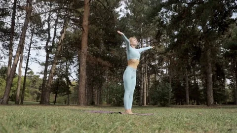 A yoga practitioner does exercises during the day in an outdoor park Stock Footage 149902418