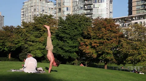 Yoga practitioner doing a handstand at the park Stock Footage 30686056