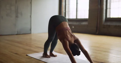 Yoga practitioner doing sun salutation in beautiful brick and beam industrial sp Stock Footage 199458552