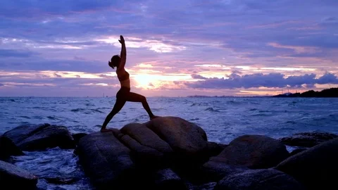 Yoga on the rock at the sunset with the murmur of waves Video stock 79873223