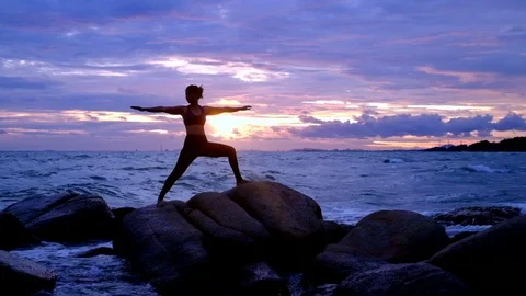 Yoga on the rock at the sunset with the murmur of waves Video stock 79874068
