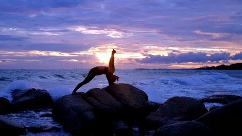Yoga on the rock at the sunset with the murmur of waves Video stock 79981644