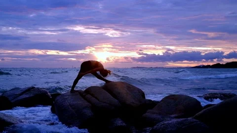 Yoga on the rock at the sunset with the murmur of waves Video stock 79981784