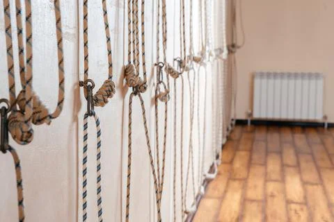 Yoga ropes hanging on empty studio wall. Iyengar yoga concept Stock Photos