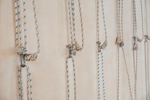 Yoga ropes hanging on empty studio wall. Iyengar yoga concept Stock Photos