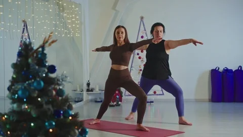 Yoga session for beginners in a cozy studio during the holiday season Stock Footage 296896237
