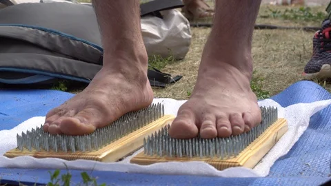 Yoga stands on sharp nails in a park outdoors. Stock Footage 127851514