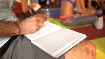 Yoga student boy taking notes in the class with other students Stock Footage 85951708