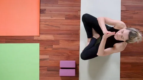 Yoga studio concept Top view of female Yoga instructor sitting with legs crossed Stock Footage 108061141