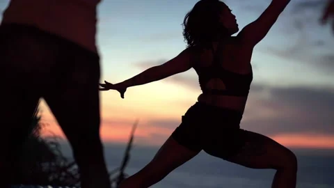 Yoga teacher performs pose against beautiful sunset Stock Footage 138593064