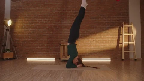 Yoga trainer doing handstand balancing on arms with legs up Stockbeeldmateriaal 233120179