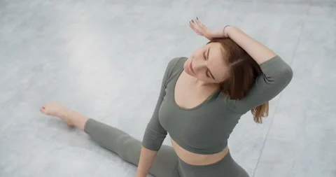 Yoga trainer performs side bends sitting on a twine, gymnastic woman with tight Stock Footage 147322981