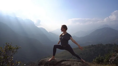 Yoga. Woman exercising and warming up on mountain cliff Stock Footage 89463556