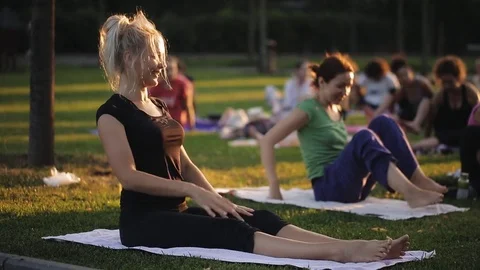 Yoga woman on green grass.. big group of adults attending a yoga class outside Stock Footage