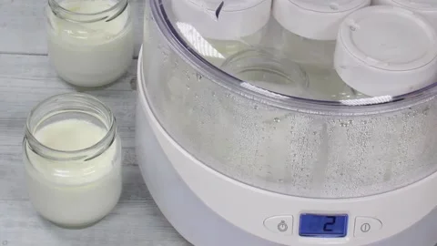 Yoghurt maker with jars of yoghurt. Healthy food. Cooking process. Water dro Stock Footage 151162541