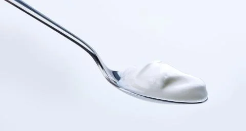 Yoghurt on silver spoon Stock Photos