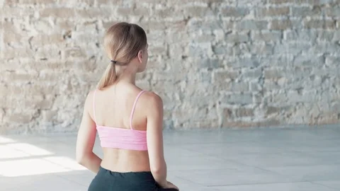 The Yogi girl is doing exercises in the middle of a large bright room. Stock Footage 80614922